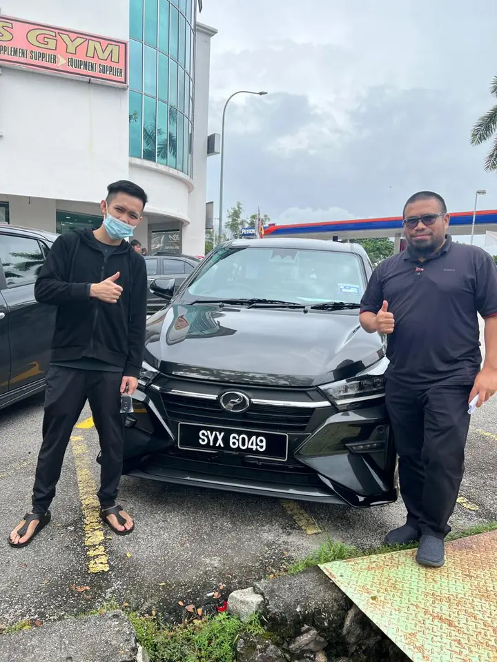 Pelanggan dan Sales Advisor bersama kereta Perodua yang telah diserahkan