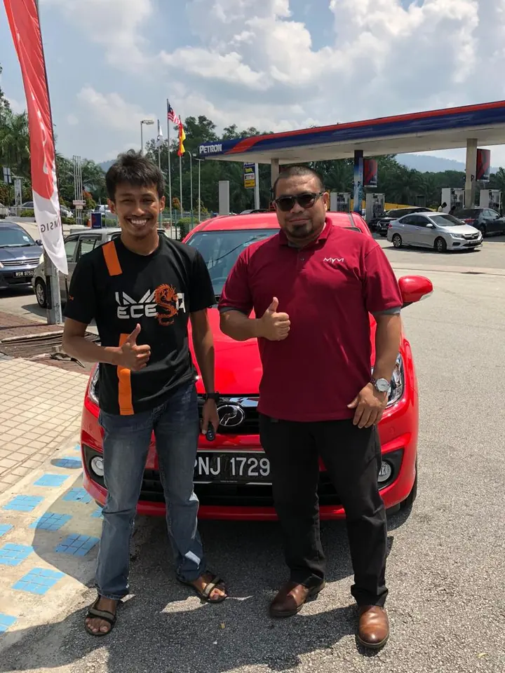 Pelanggan dan Sales Advisor bergambar bersama kereta Perodua merah