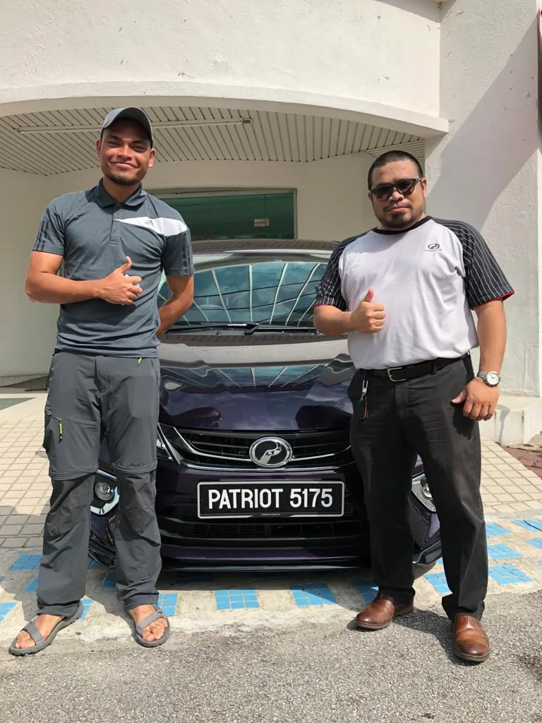 Pelanggan dan Sales Advisor bergambar bersama kereta Perodua selepas penyerahan